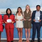 Students winning a scholarship holding a plaque.