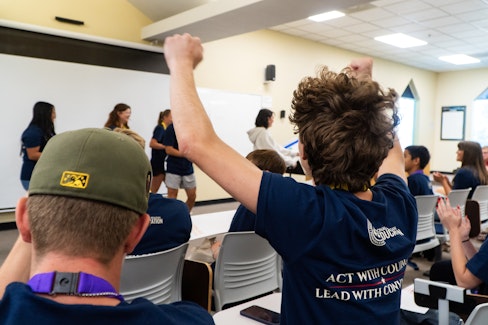 Student raising his hands in the air in triumph