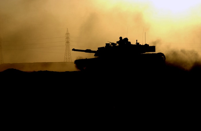 A US Army (USA) M1 Abrams Main Battle Tank (MBT), Apache Troop, 2nd Battalion, 7th Cavalry Regiment (2-7 CAV), 2nd Brigade Combat Team (BCT), 1ST Cavalry Division (CAV DIV), returns to battle within the city after refueling and reloading during major combat operation in Fallujah during Operation IRAQI FREEDOM