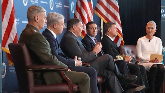 Men in chairs on stage