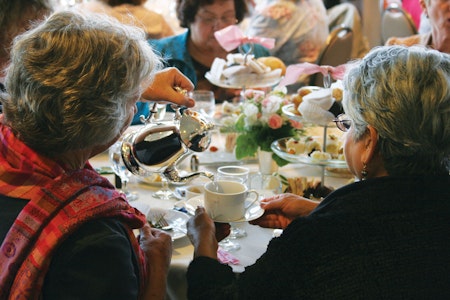 Woman pouring tea for another woman