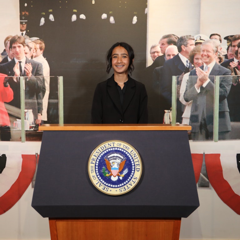 Student at Podium Female Student at Presidential Podium
